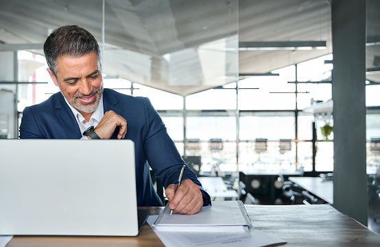 Businessman smiling while working on a laptop