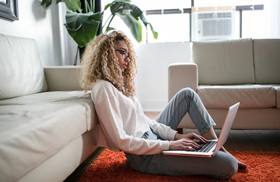 Woman sitting on the floor learning on a laptop