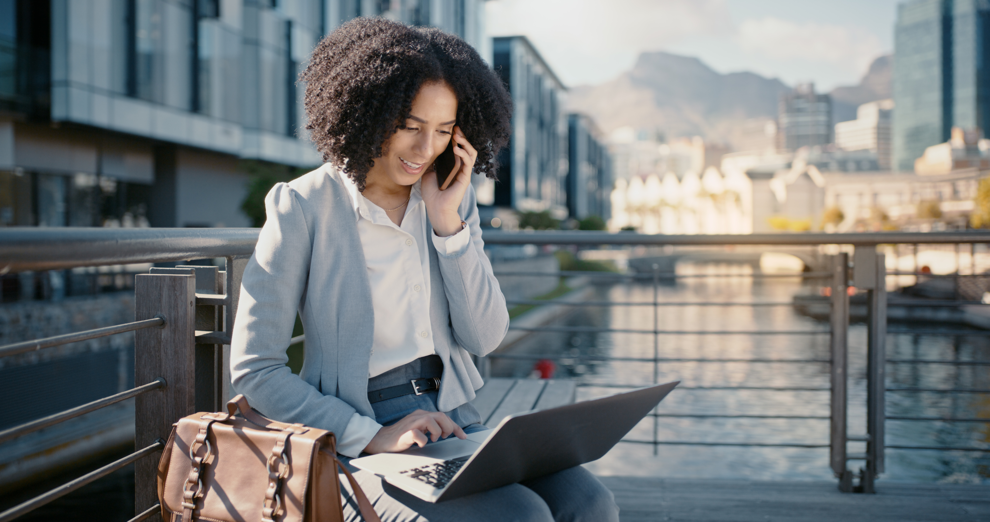 Woman working on laptop by waterfront